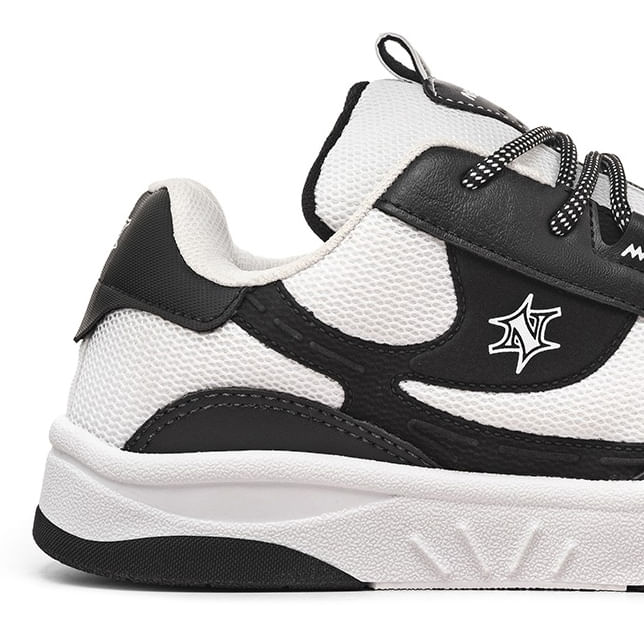 Tênis casual urbano masculino preto e branco visto de outro ângulo mostrando detalhes do cadarço e sola
